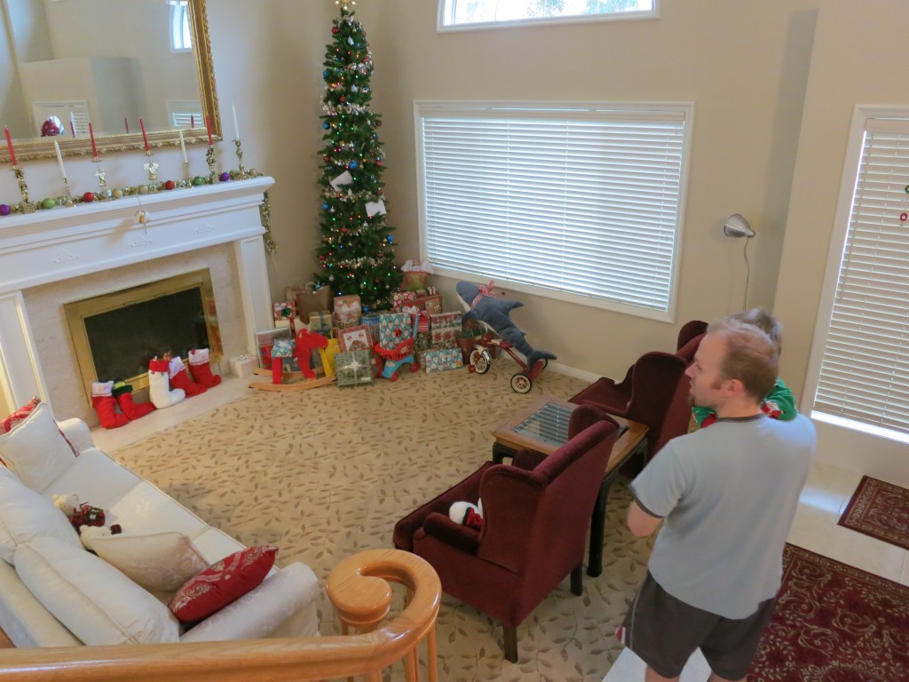 I had visions of Emrick running downstairs on Christmas morning and diving into the presents. But he was still feeling pretty sick at that point, so  here is Marcus holding him and trying to get him to look at all the goodies under the tree. 