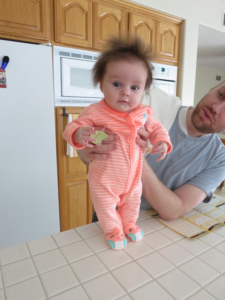 Holly with her hair finally dry. Daddy props her up on the kitchen island while the pre-cooked turkey breast is being reheated in the oven.